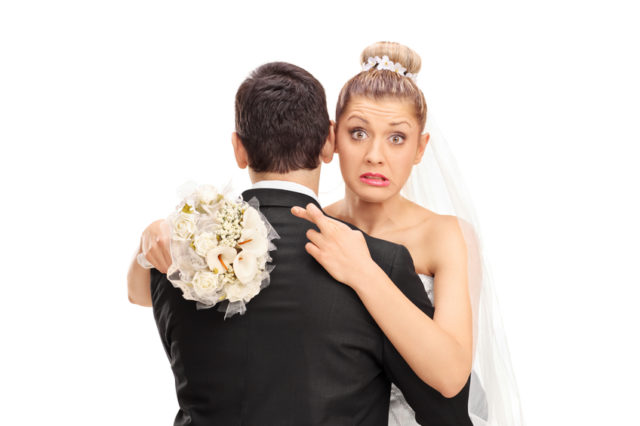 Heiratsschwindel -Braut kreuzt finger hinter dem Rücken des Bräutigams